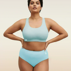 Woman wearing a blue bra and underwear set on a beige background