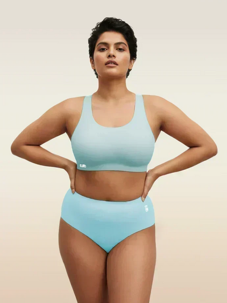 Woman wearing a blue bra and underwear set on a beige background