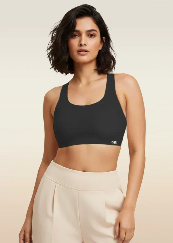 Woman wearing a black sports bra with a visible brand logo on a beige background