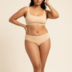 Woman wearing beige bra and underwear on a beige background