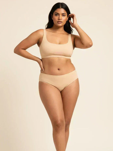 Woman wearing beige bra and underwear on a beige background
