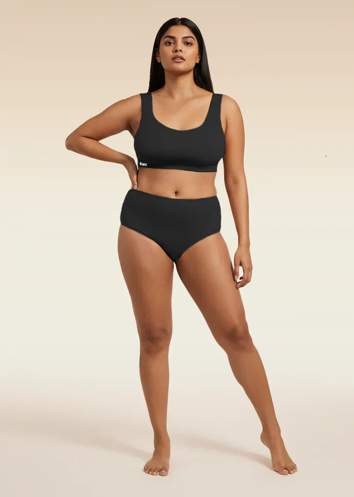 Woman wearing a black bra and underwear set on a beige background