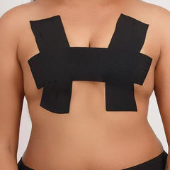 Front view of a person wearing black adhesive boob tape applied in a supportive H-pattern.