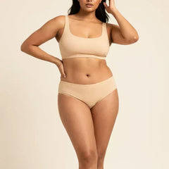 Woman wearing beige bra and underwear on a beige background