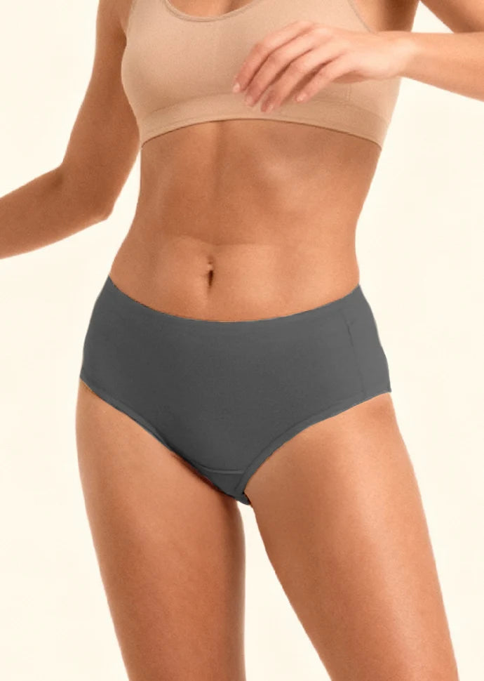 Person wearing a beige sports bra and gray mid-waist underwear on a plain background