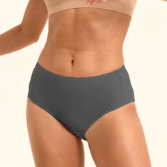 Person wearing a beige sports bra and gray mid-waist underwear on a plain background