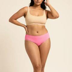 Woman wearing a beige bikini top and pink low-waist underwear on a beige background