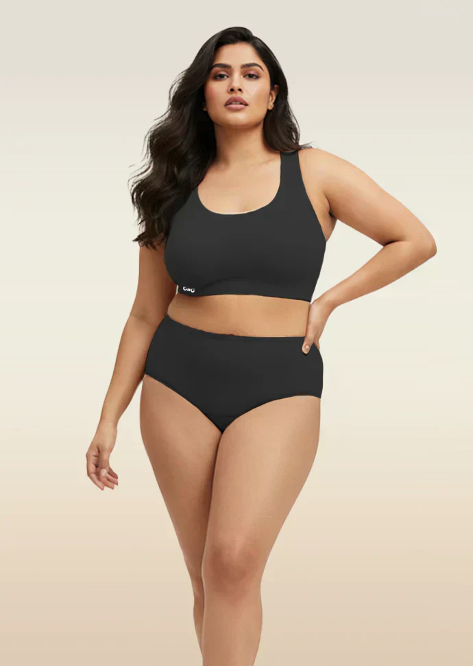 Woman wearing a black bra and underwear set on a beige background