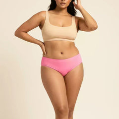 Woman wearing a beige bikini top and pink low-waist underwear on a beige background