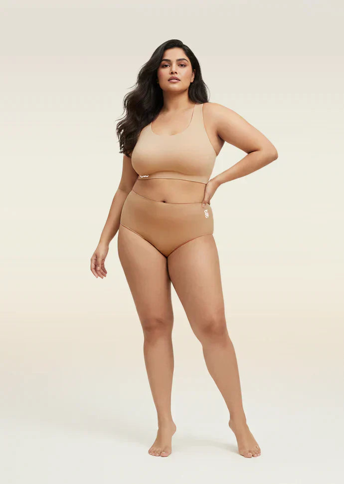 Woman wearing a beige bra and  underwear set on a beige background