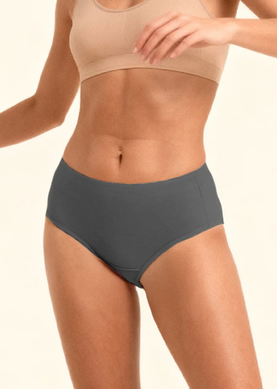 Person wearing a beige sports bra and gray mid-waist underwear on a plain background