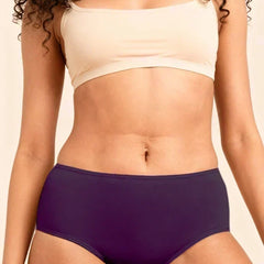 Person wearing a beige bra and violet mid-waist underwear against a neutral background