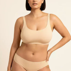 Woman wearing a beige bra and panties  on a beige background