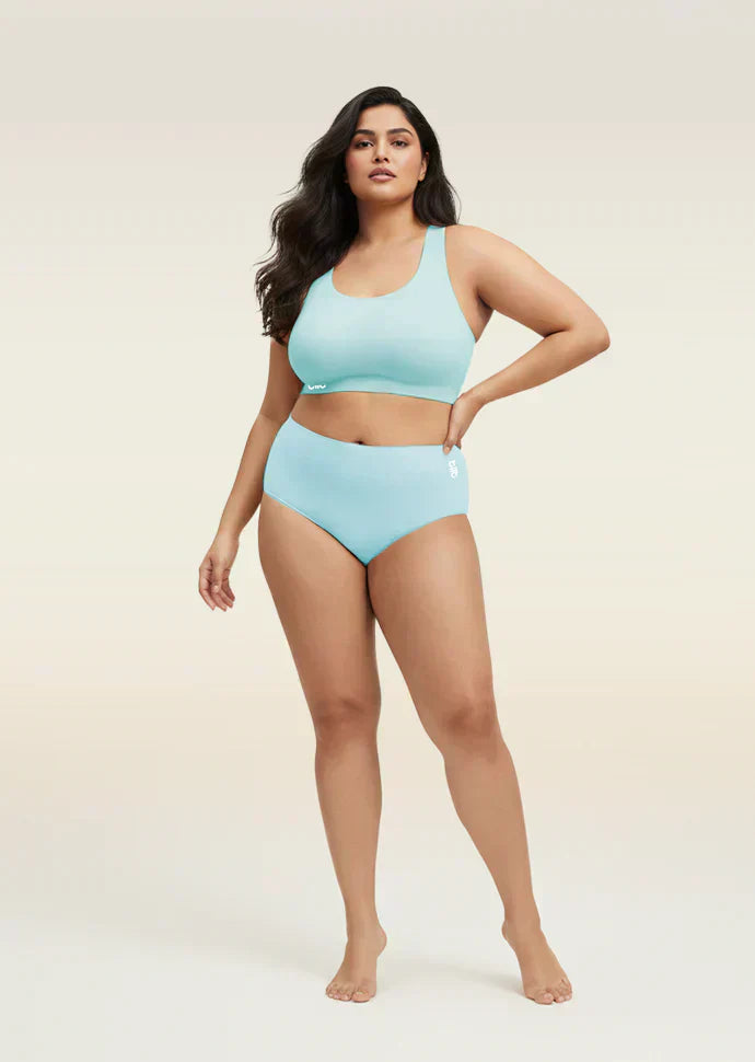 Woman wearing a blue bra and underwear set on a beige background