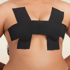 Black boob tape worn by a person on a plain background