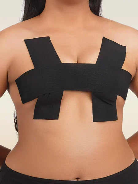 Black boob tape worn by a person on a plain background