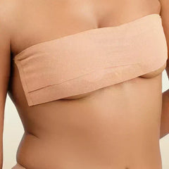 Beige boob tape worn by a person on a beige background