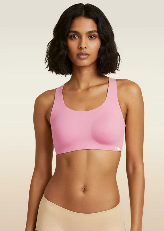 Woman wearing a pink sports bra against a beige background