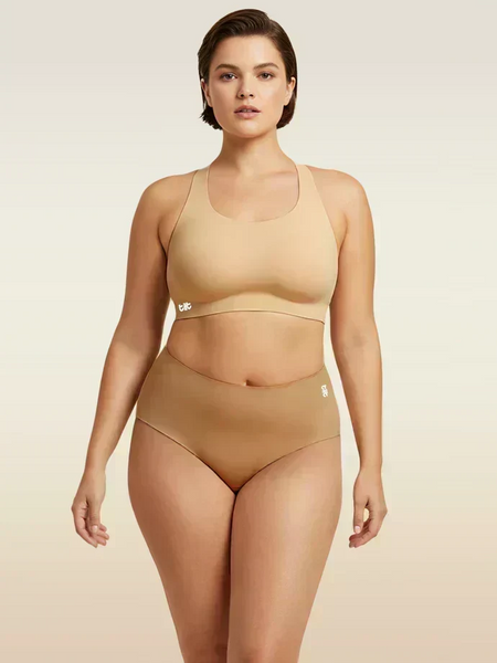 Woman wearing a beige bra and  underwear set on a beige background