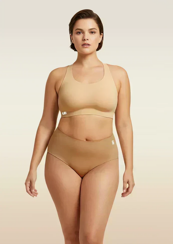 Woman wearing a beige bra and  underwear set on a beige background