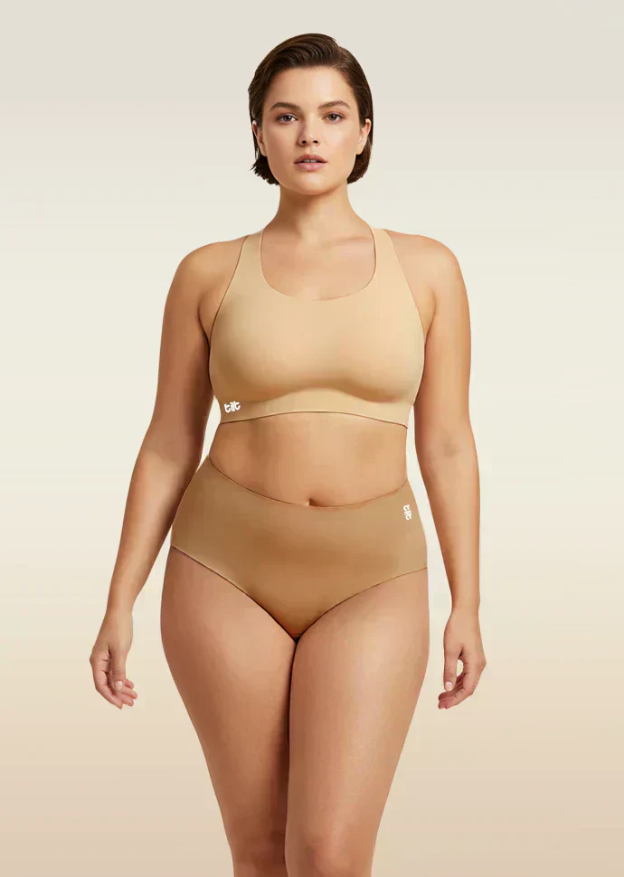 Woman wearing a beige bra and  underwear set on a beige background