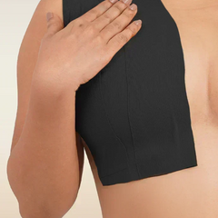 Person wearing a black boob tape on a beige background