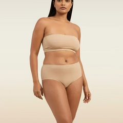 Woman wearing a beige strapless top and mid-waist underwear on a beige background