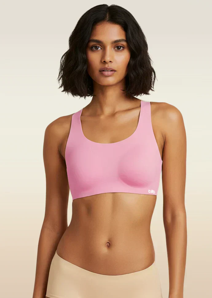 Woman wearing a pink sports bra against a beige background