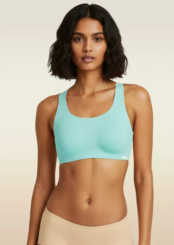 Woman wearing a blue sports bra against a beige background