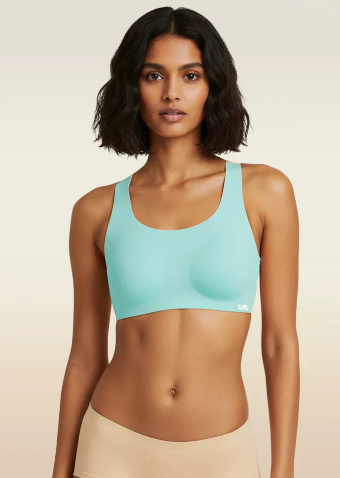Woman wearing a blue sports bra against a beige background