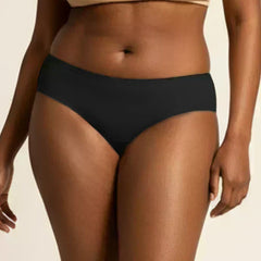 Person wearing black underwear and beige bra on a neutral background