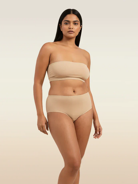 Woman wearing a beige strapless top and mid-waist underwear on a beige background