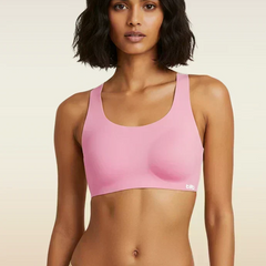 Woman wearing a pink sports bra against a beige background