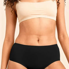 Person wearing a beige bra and black  underwear against a neutral background