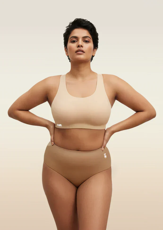 Woman wearing a beige bra and  underwear set on a beige background