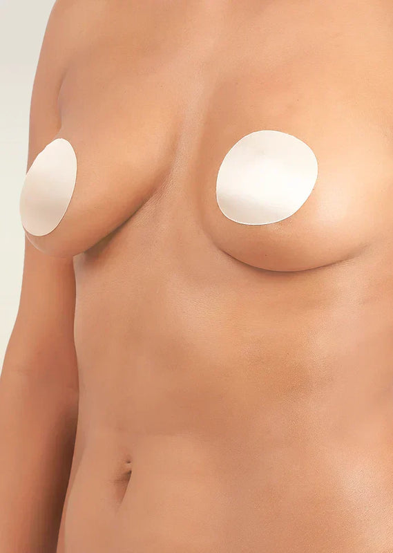 Nipple cover patches on a person's chest against a neutral background