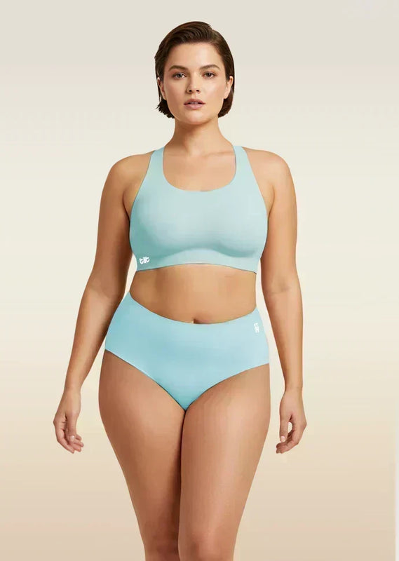 Woman wearing a blue bra and underwear set on a beige background
