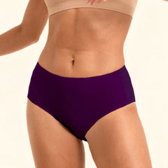 Person wearing a beige sports bra and violet mid-waist underwear  on a plain background