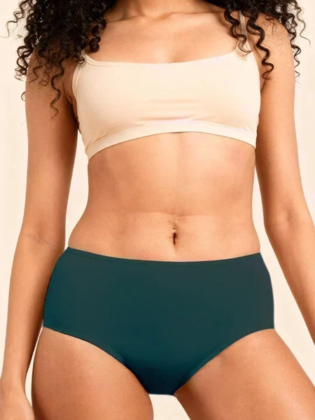Person wearing a beige sports bra and teal mid-waist underwear on a neutral background