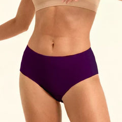 Person wearing a beige sports bra and violet mid-waist underwear  on a plain background