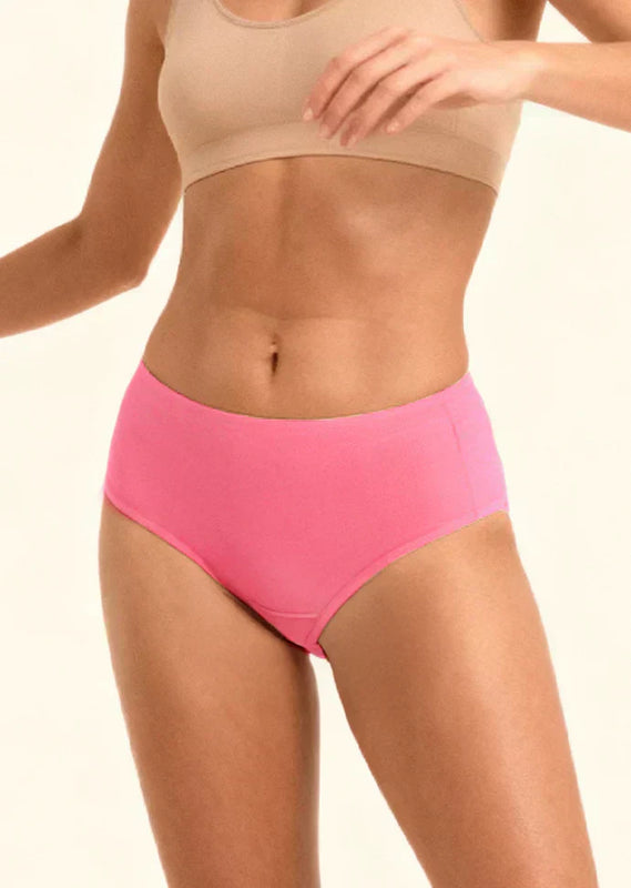 Person wearing a beige sports bra and pink mid-waist underwear on a plain background