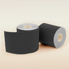 Two rolls of black tape on a beige background