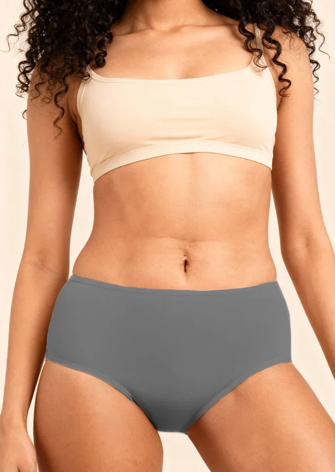 Person wearing a beige bra and gray underwear on a beige background