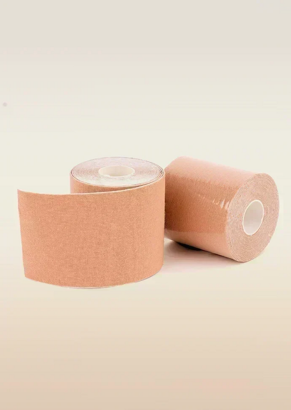 Two rolls of beige boob tape on a beige background