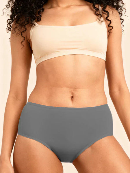 Person wearing a beige bra and gray underwear on a beige background