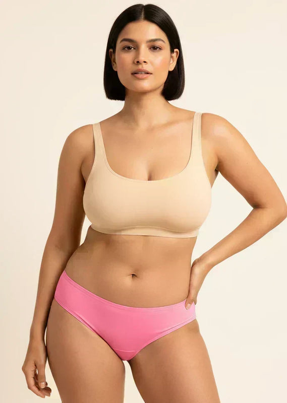 Woman wearing a beige bra and pink underwear on a beige background