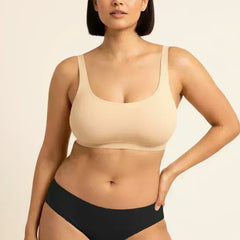 Woman wearing a beige bra and black underwear on a beige background