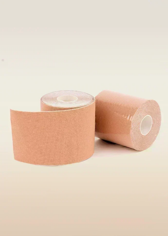 Two rolls of beige boob tape on a beige background