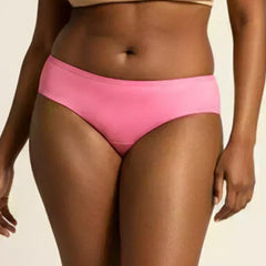 Person wearing pink low-waist underwear and beige bra on a neutral background