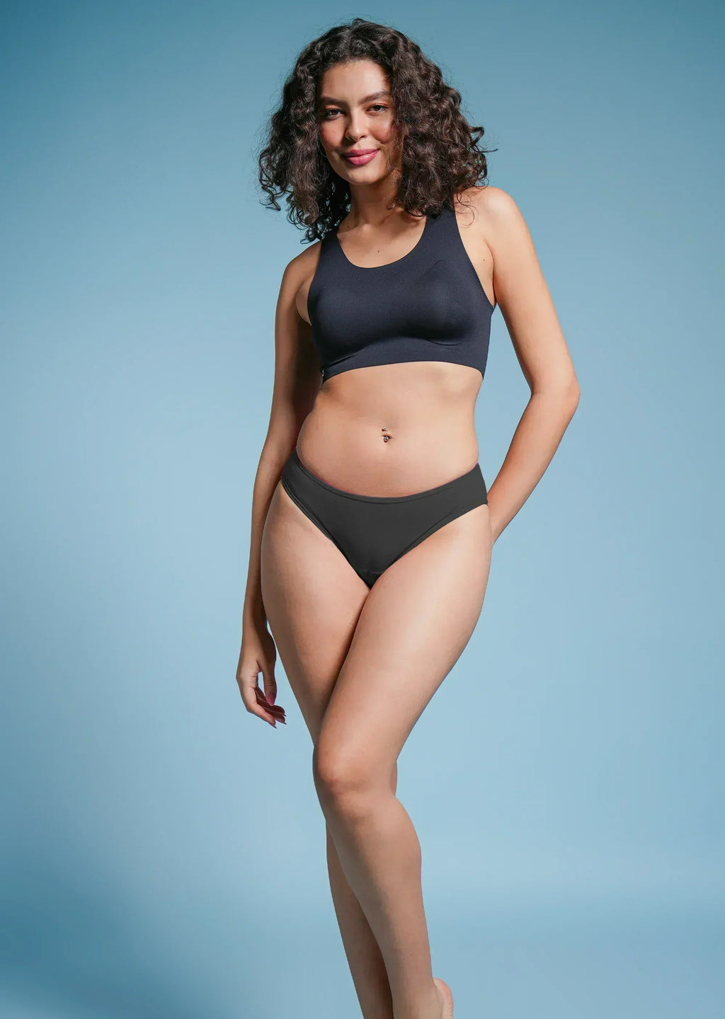 Woman wearing a black bikini against a light blue background